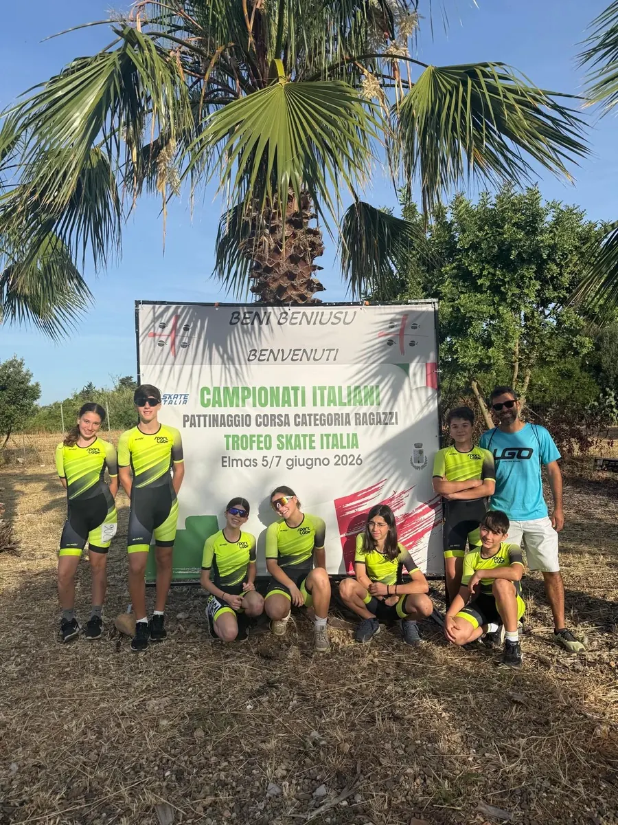 Gli atleti Ragazzi di ASD Sport Lab con il tecnico davanti allo striscione dei Campionati Italiani di pattinaggio corsa su pista di Elmas 2026