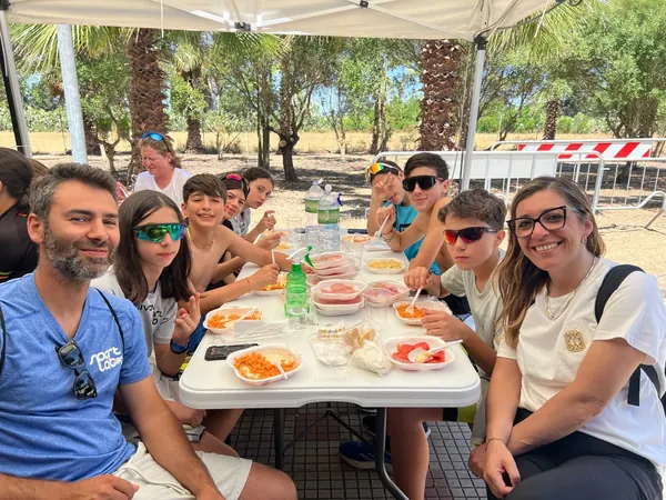 Atleti e staff di Sport Lab a pranzo all'ombra del gazebo a Elmas