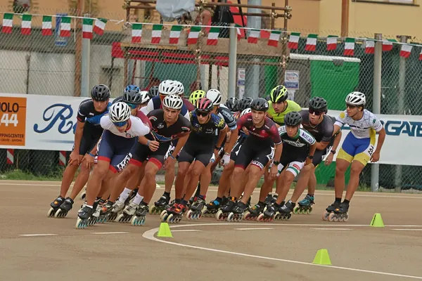 Gruppo compatto in curva, tra i coni e le bandierine tricolori