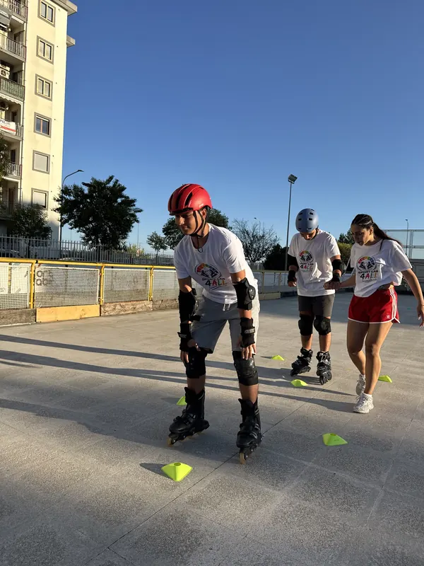 Atleti Skate4All pattinano tra i coni accompagnati in pista