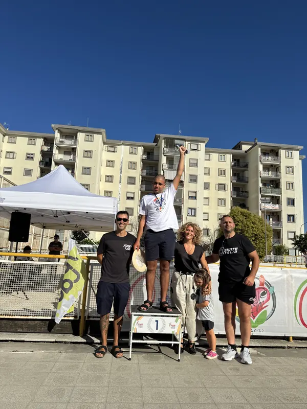 Atleta sul primo gradino del podio festeggia con tecnici e famiglia