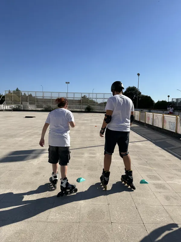 Un atleta pattina tra i coni insieme al suo maestro