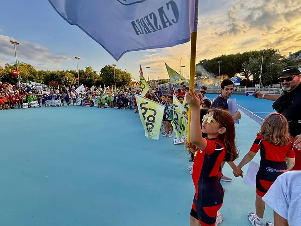 Le società in pista con le bandiere durante la sfilata inaugurale al tramonto