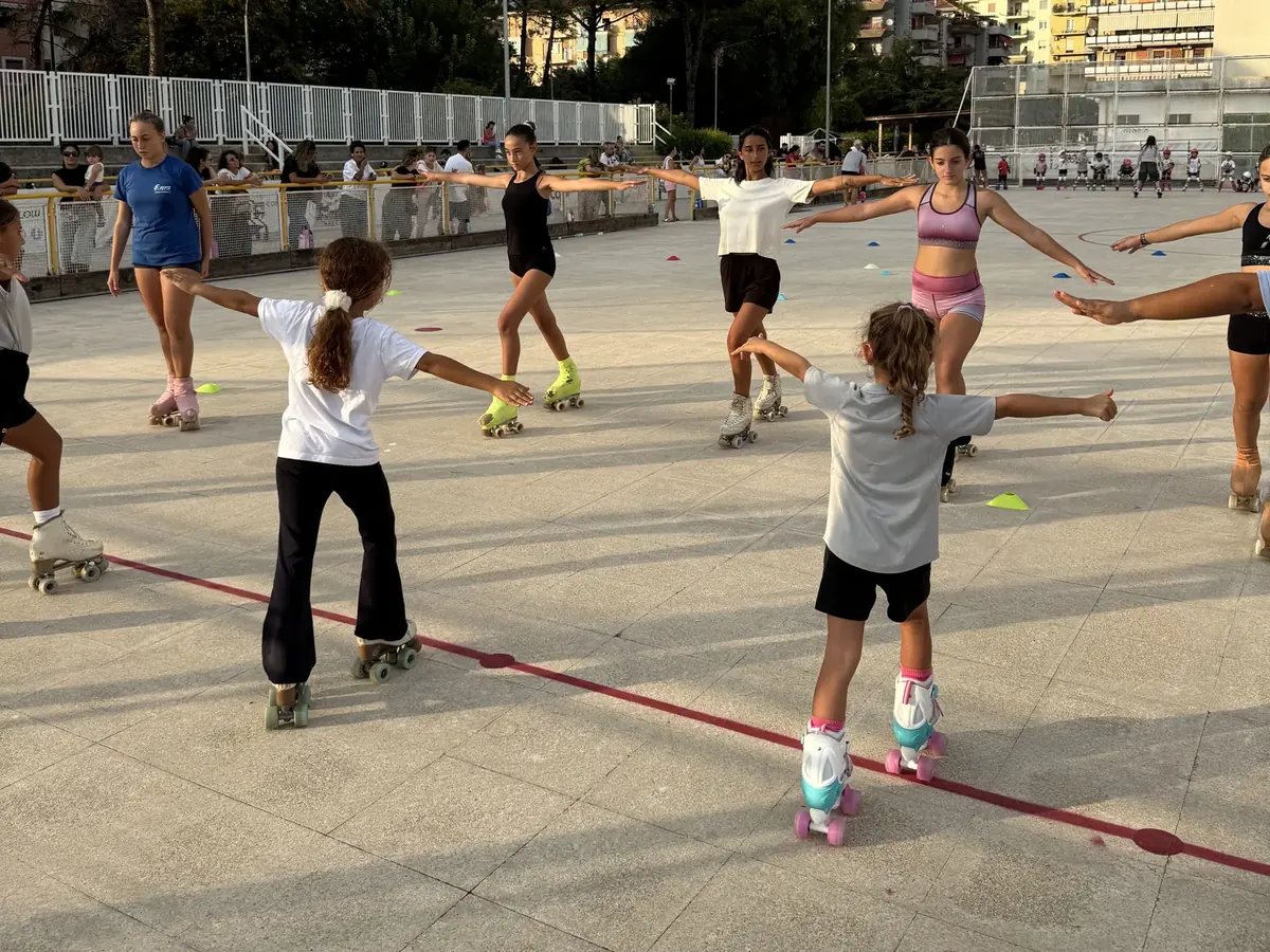Bambini con le braccia aperte tra i coni durante il corso di pattinaggio artistico per principianti di ASD Sport Lab a Pontecagnano