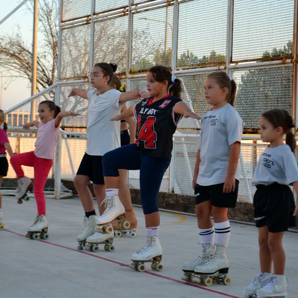 Bambine in fila durante un esercizio di equilibrio su un piede nel corso di pattinaggio artistico