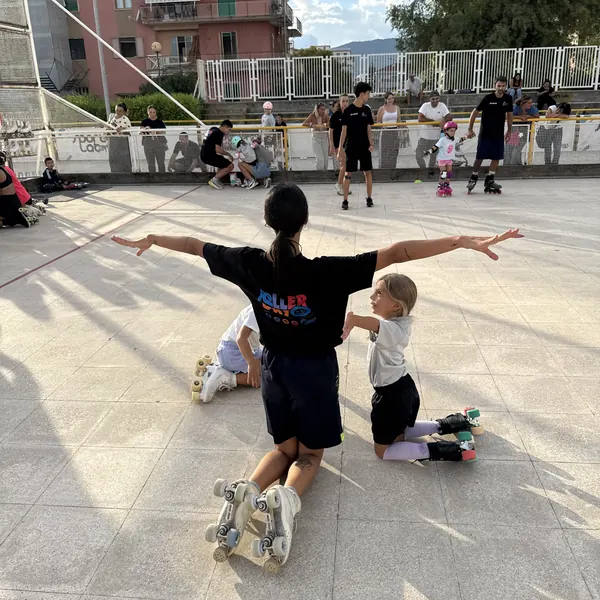 Istruttrice con le bambine più piccole ai primi passi sui pattini a rotelle