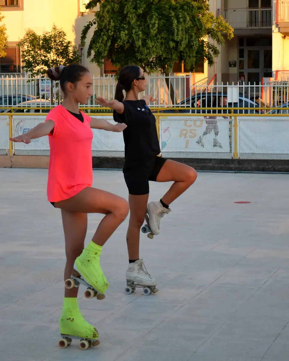 Due atlete del gruppo agonisti di pattinaggio artistico ASD Sport Lab in equilibrio su un piede con le braccia aperte