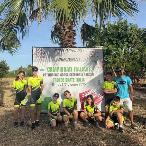Atleti di ASD Sport Lab davanti allo striscione dei Campionati Italiani di pattinaggio corsa su pista di Elmas